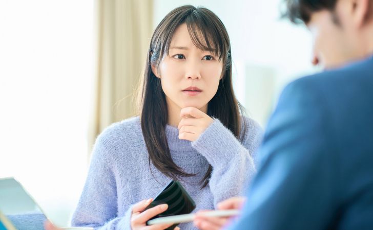 武蔵コーポレーションの担当者に不信感を抱く女性